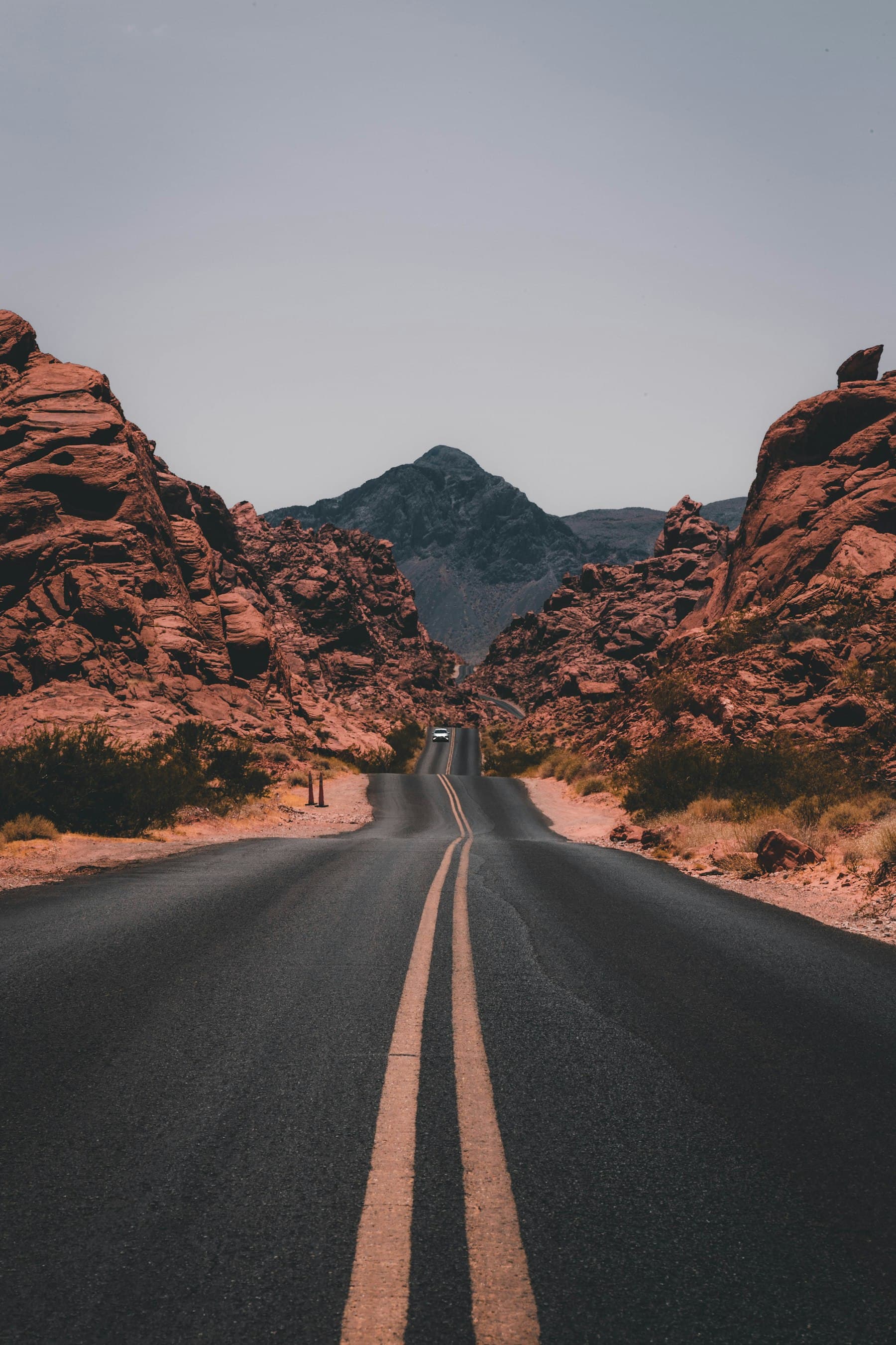 Route sinueuse traversant un canyon rouge au coucher du soleil