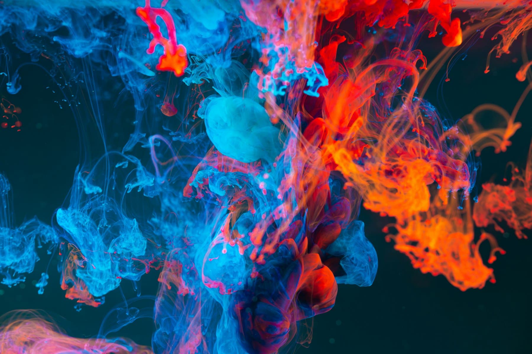 Nuage d’encre bleu, rouge et turquoise dans l’eau